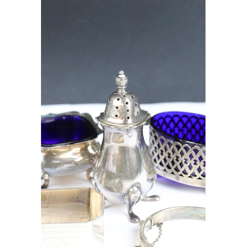 115 - A collection of hallmarked sterling silver to include cruet set, napkin rings and silver bangles.