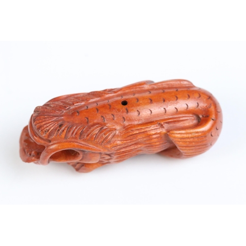 122 - Two carved wooden netsuke figures of Chinese dragons, one holding a large ball signed