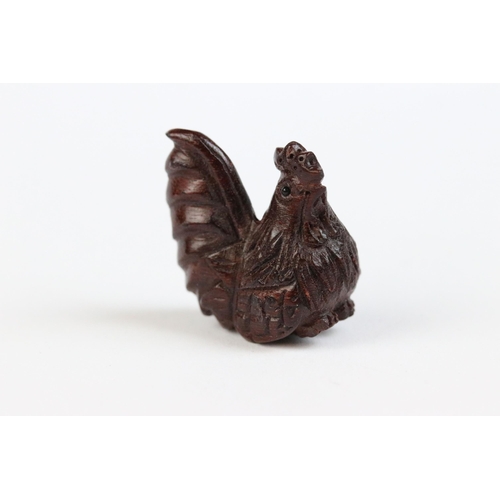 124 - Three miniature wood netsuke figures to include dragon, hen and peculiar face