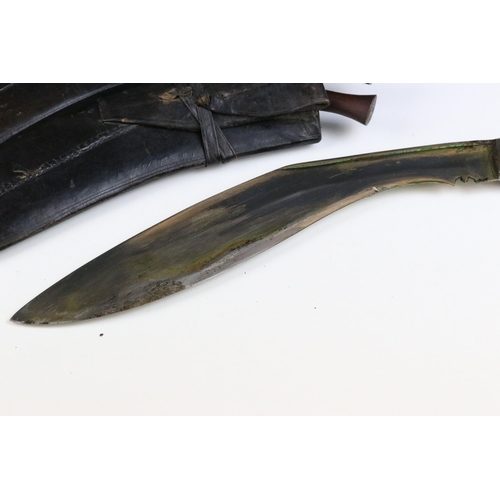 126 - Two mid 20th century Kukri knives, Chirra blade with grooved fuller, wooden grips and leather covere... 