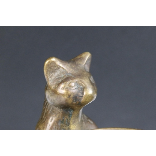 85 - A bronze figure of a standing cat holding a tray.