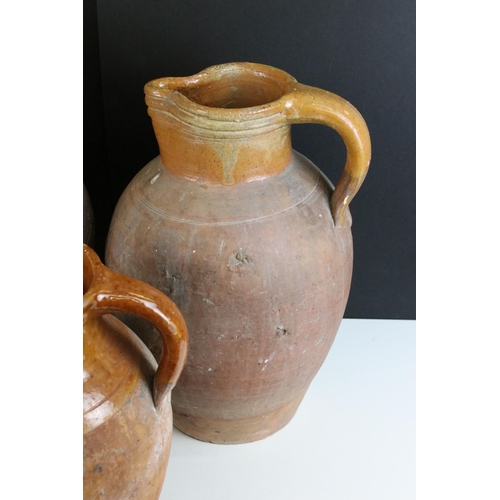 192 - Trio of large pottery harvest jugs with glazed tops, largest H 44cm, smallest H 32cm