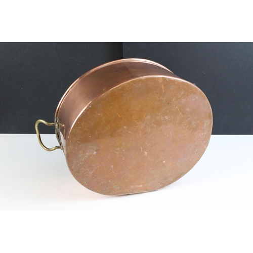 213 - Copper oval planter with twin brass loop handles, 39cm long