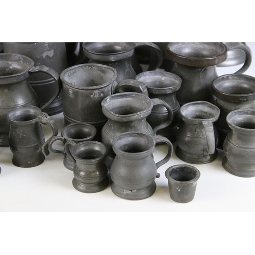 253 - Quantity of pewter items to include a pair of candlesticks, tankards of varying sizes, some with gla... 