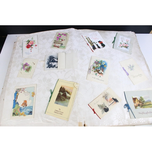 295 - Collection of postcards and greetings cards across three albums to include one large album of greeti... 