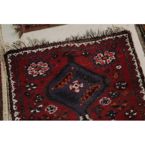 476 - Group of four rugs, one red ground example with three diamond pattern to centre, measures 124cm x 75... 