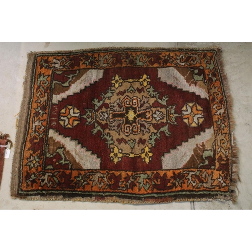 476 - Group of four rugs, one red ground example with three diamond pattern to centre, measures 124cm x 75... 