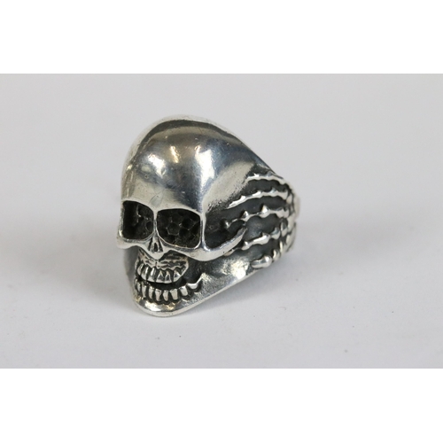 257 - A collection of three white metal skull rings together with a vesta case in the form of the devil.