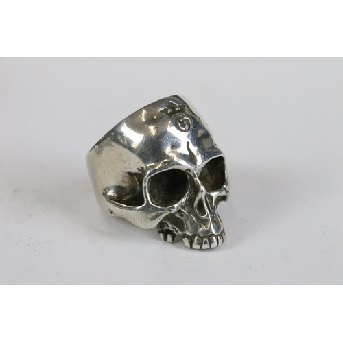 257 - A collection of three white metal skull rings together with a vesta case in the form of the devil.