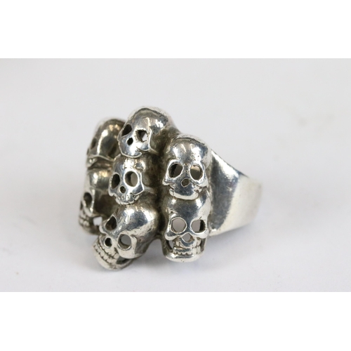 257 - A collection of three white metal skull rings together with a vesta case in the form of the devil.