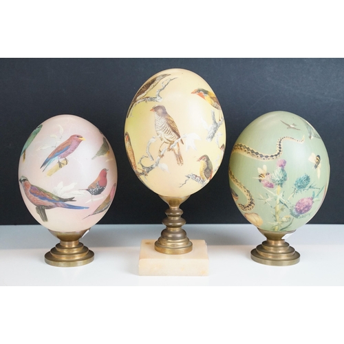 5 - Set of three ceramic hand painted decorative eggs on stands with bird, snakes and wildlife design, t... 