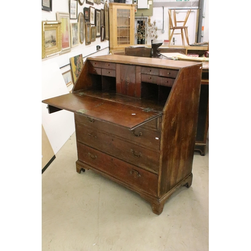 553 - 19th Century oak bureau chest having a bank of four drawers with fold down desk revealing further dr... 