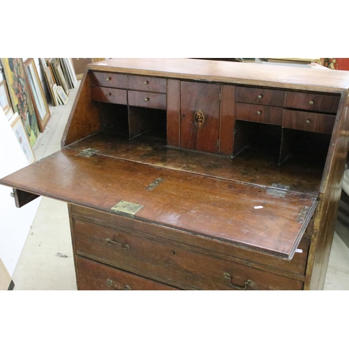 553 - 19th Century oak bureau chest having a bank of four drawers with fold down desk revealing further dr... 