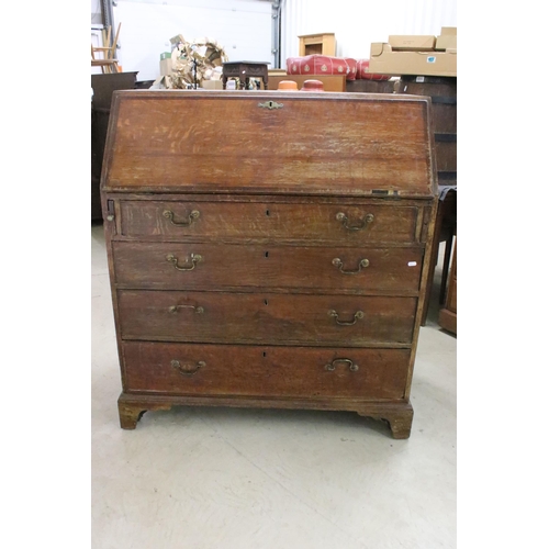 553 - 19th Century oak bureau chest having a bank of four drawers with fold down desk revealing further dr... 