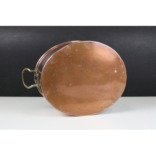 96 - Copper oval pot or planter with rolled rim and twin brass loop handles, 34cm long