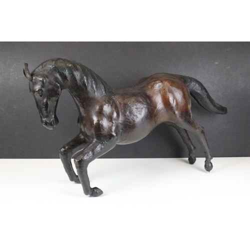 114 - Pair of leather Liberty style covered model horses with glass eyes, tallest H 33.5cm