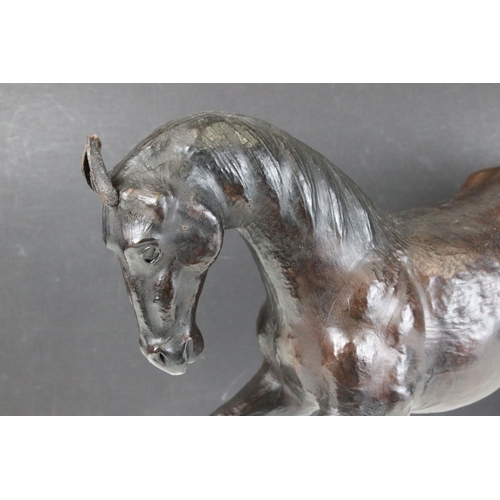 114 - Pair of leather Liberty style covered model horses with glass eyes, tallest H 33.5cm