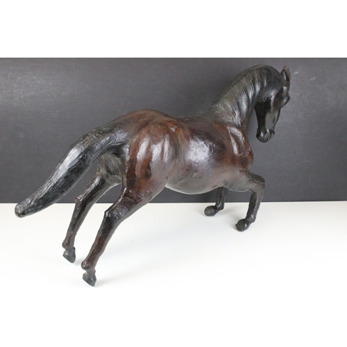 114 - Pair of leather Liberty style covered model horses with glass eyes, tallest H 33.5cm