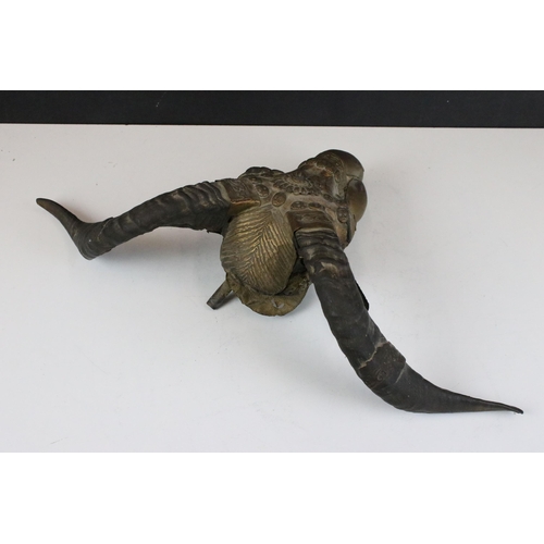 135 - Horned goat skull ornamented with metal applique and skull detail, W 27cm