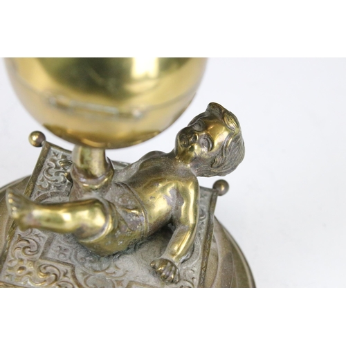 137 - Brass boy and ball on carpet inkwell on stand, H 14cm