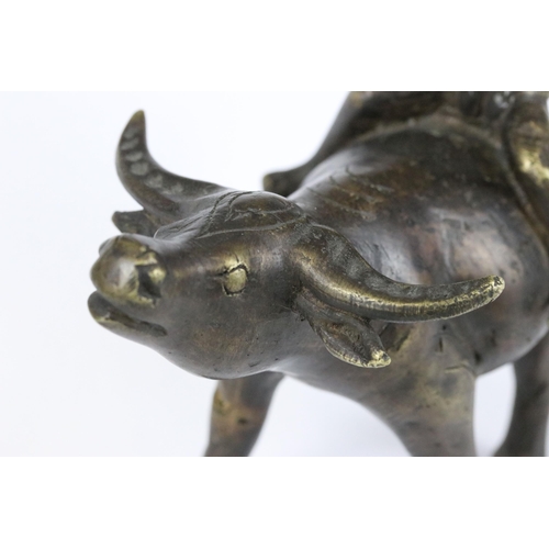 182 - A Chinese cast bronze / brass metal ornamental figure of a ox with mounted man playing the flute, st... 