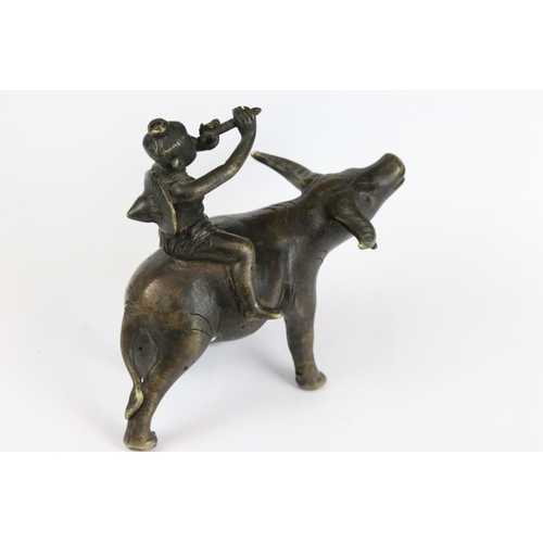 182 - A Chinese cast bronze / brass metal ornamental figure of a ox with mounted man playing the flute, st... 