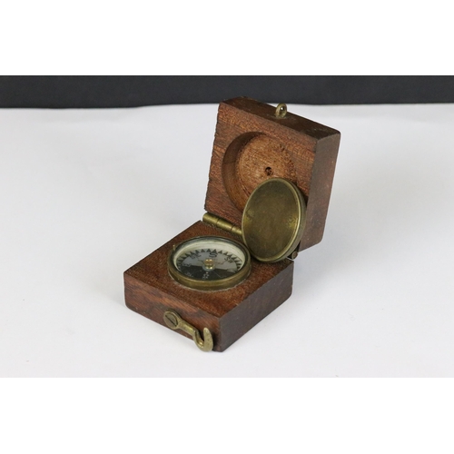 183 - An early to mid 20th century brass cased pocket compass set within a wooden box together with leathe... 