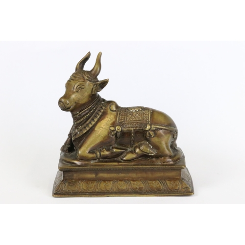 194 - Two Indian bronze / brass ornamental figures to include an ox on plinth and a man of horseback, toge... 