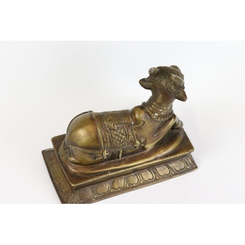 194 - Two Indian bronze / brass ornamental figures to include an ox on plinth and a man of horseback, toge... 