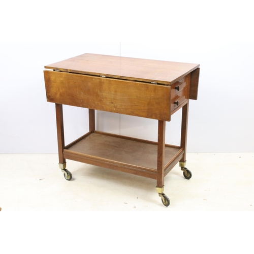 587 - Stanley Webb Davies 1946 oak drop leaf table with side drawers and lower shelf set on castors, H 73c... 