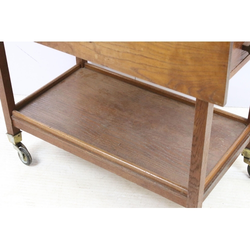 587 - Stanley Webb Davies 1946 oak drop leaf table with side drawers and lower shelf set on castors, H 73c... 