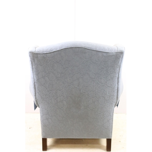 606 - Large wing back armchair raised on square legs, approx. H 105cm