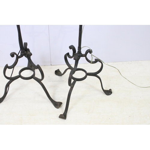 612 - Pair of wrought iron scroll tripod base floor lamps with old deed type fringed lamp shades, H 176cm