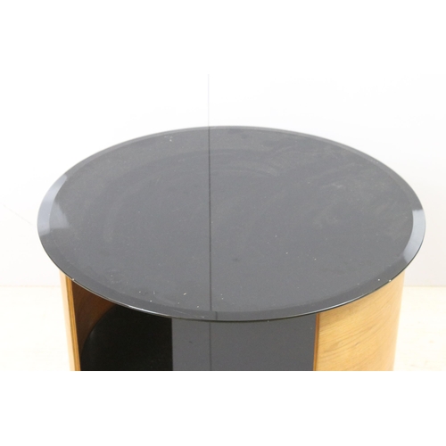 562 - Curved teak side lamp table with black glass top, diameter 61cm