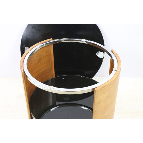 562 - Curved teak side lamp table with black glass top, diameter 61cm