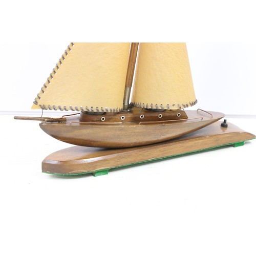 646 - Art Deco table lamp in the form of a boat of wooden construction with two hide sails and flag, measu... 