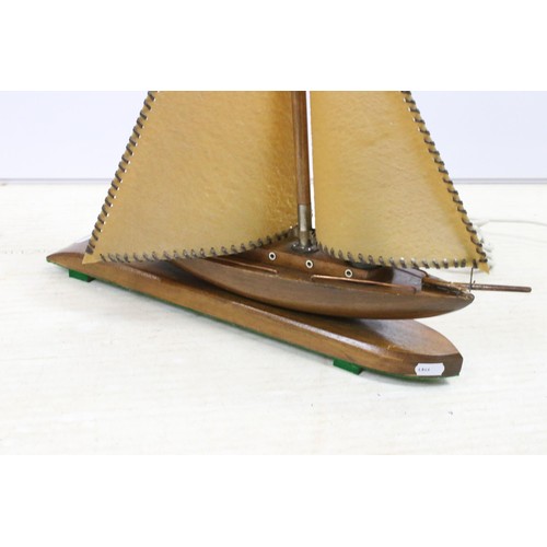 646 - Art Deco table lamp in the form of a boat of wooden construction with two hide sails and flag, measu... 