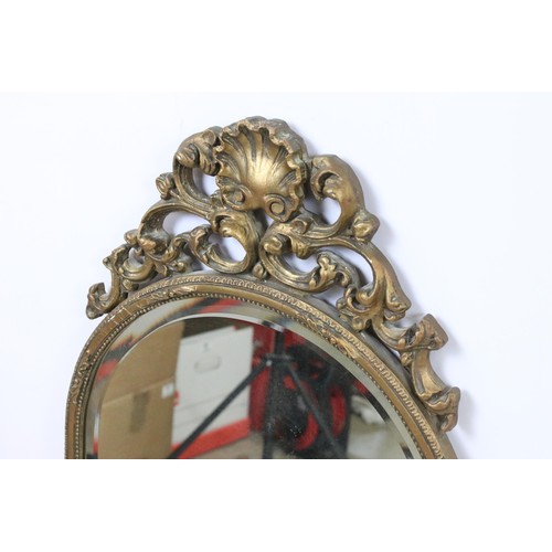 547 - Early 20th century gilt wall mirror with shell pediment above arched shaped bevelled glass within sc... 