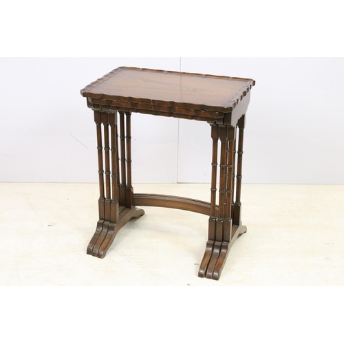 576 - 20th century mahogany nest of three tables with raised shaped edges above turnd legs and bowed suppo... 