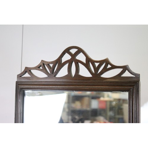 643 - Full length mahogany mirror with fret work pediment set on box plinth with castors, approx. H 172cm