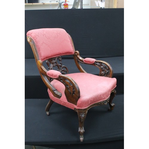 649 - An Edwardian armchair with ornate back and carved arms, raised on casters