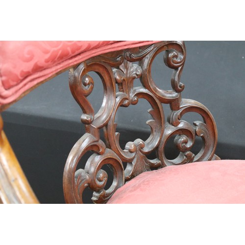 649 - An Edwardian armchair with ornate back and carved arms, raised on casters