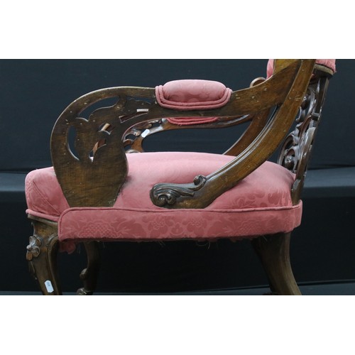 649 - An Edwardian armchair with ornate back and carved arms, raised on casters