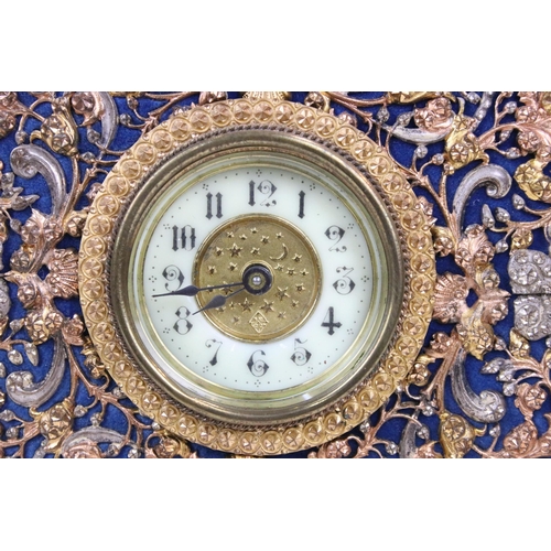 122 - British United Clock Co velvet backed clock decorated with coloured metals foliage detail and moon a... 