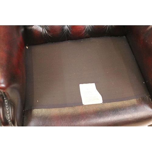 613 - Oxblood leather chesterfield wing back arm chair having button back seat with cabriole legs. Measure... 