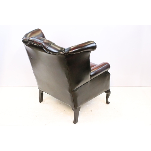 613 - Oxblood leather chesterfield wing back arm chair having button back seat with cabriole legs. Measure... 