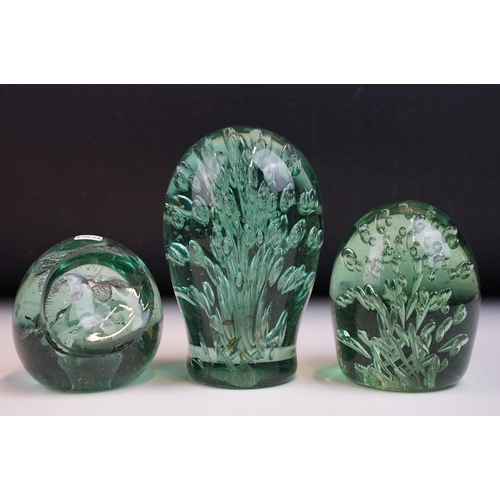 17 - Three Victorian hand blown green glass dump paperweights with interior flower and bubble patterns, t... 