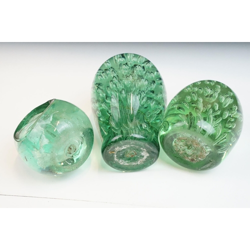 17 - Three Victorian hand blown green glass dump paperweights with interior flower and bubble patterns, t... 