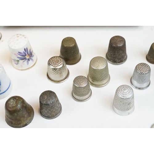 39 - Souvenir ceramic thimbles together with metal examples and wall display shelf along with an assortme... 