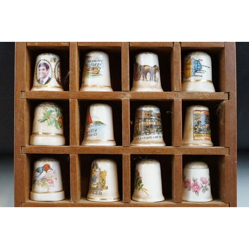 39 - Souvenir ceramic thimbles together with metal examples and wall display shelf along with an assortme... 